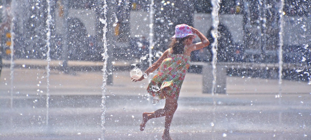 Una niña juega en unas fuentes para aliviar el calor del verano.