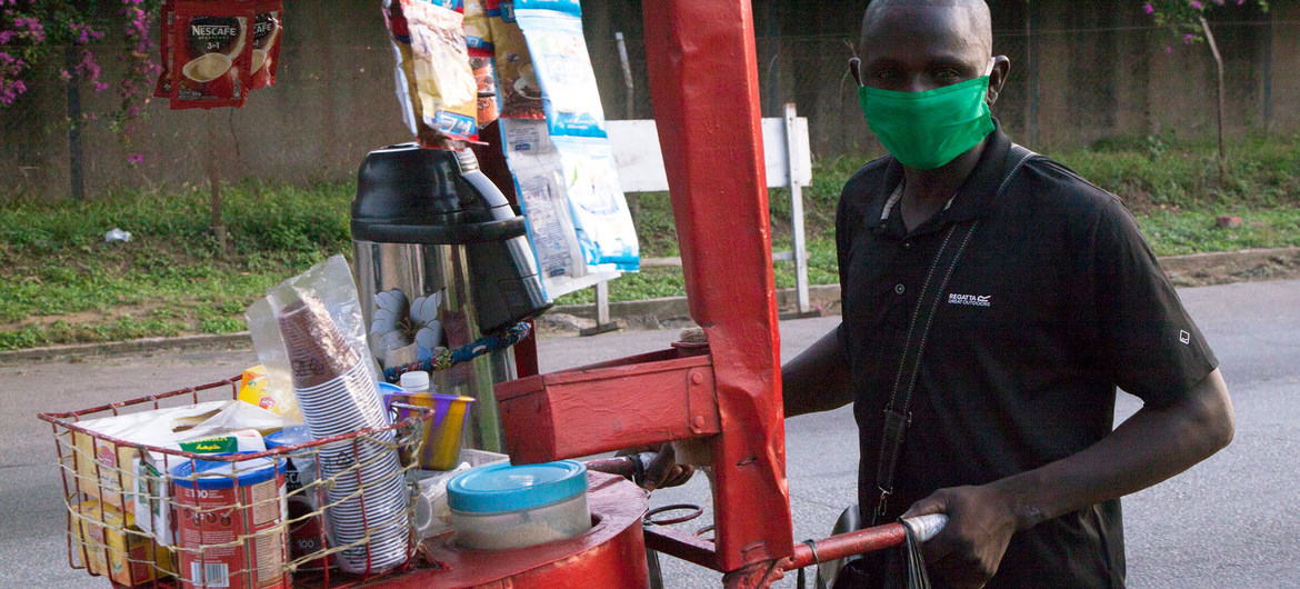 Un vendedor informal de Costa de Marfil utiliza mascarilla para protegerse del coronavirus.