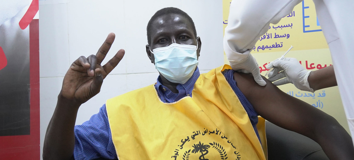 Un trabajador sanitario sudanés haciendo el signo de la victoria mientras se vacuna contra el COVID-19.