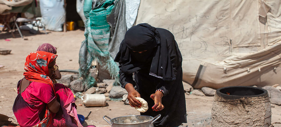 Karima, de 7 años, ve cómo su madre prepara pan en Yemen, donde el conflicto ha agravado la fatla de alimentos.