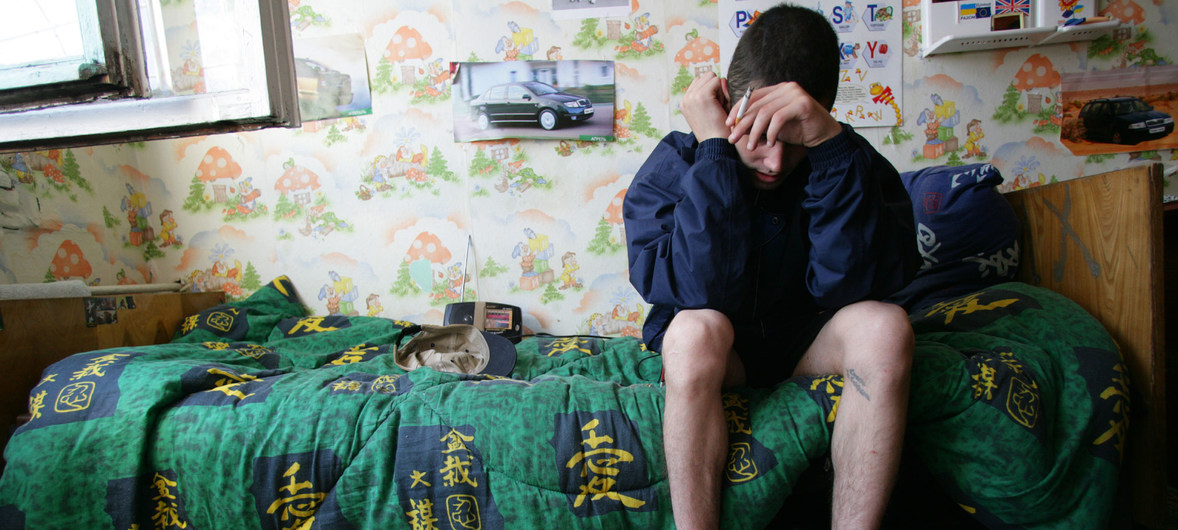 Un muchacho de 19 años se sienta en su cama en un refugio para niños que viven o trabajan en las calles, en Odessa, Ucrania. El joven consume de drogas y tiene VIH, pero no tiene acceso a medicamentos antirretrovirales.