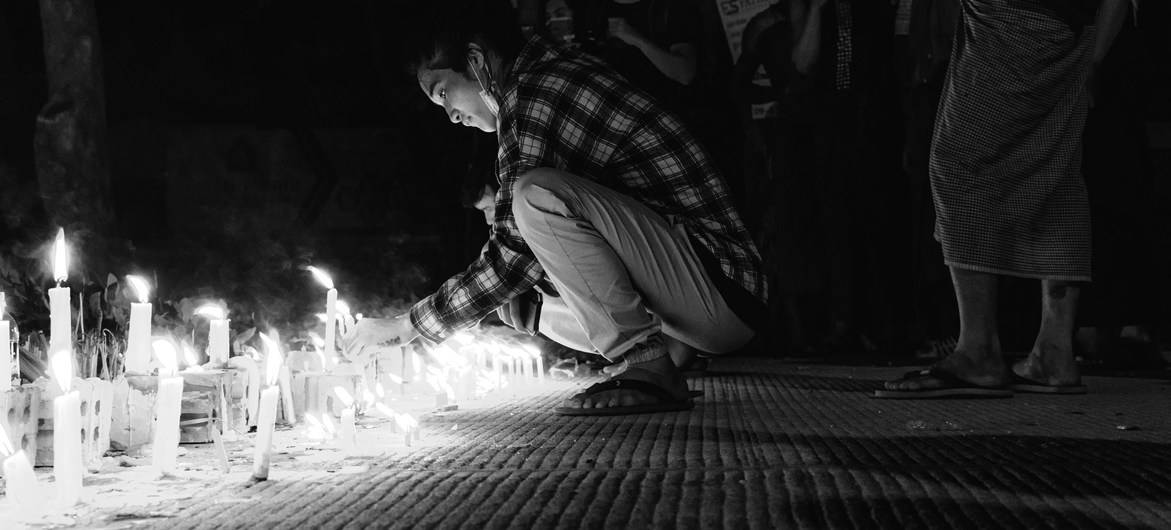 Un joven ilumina una vela en Yangon, en Myanmar.