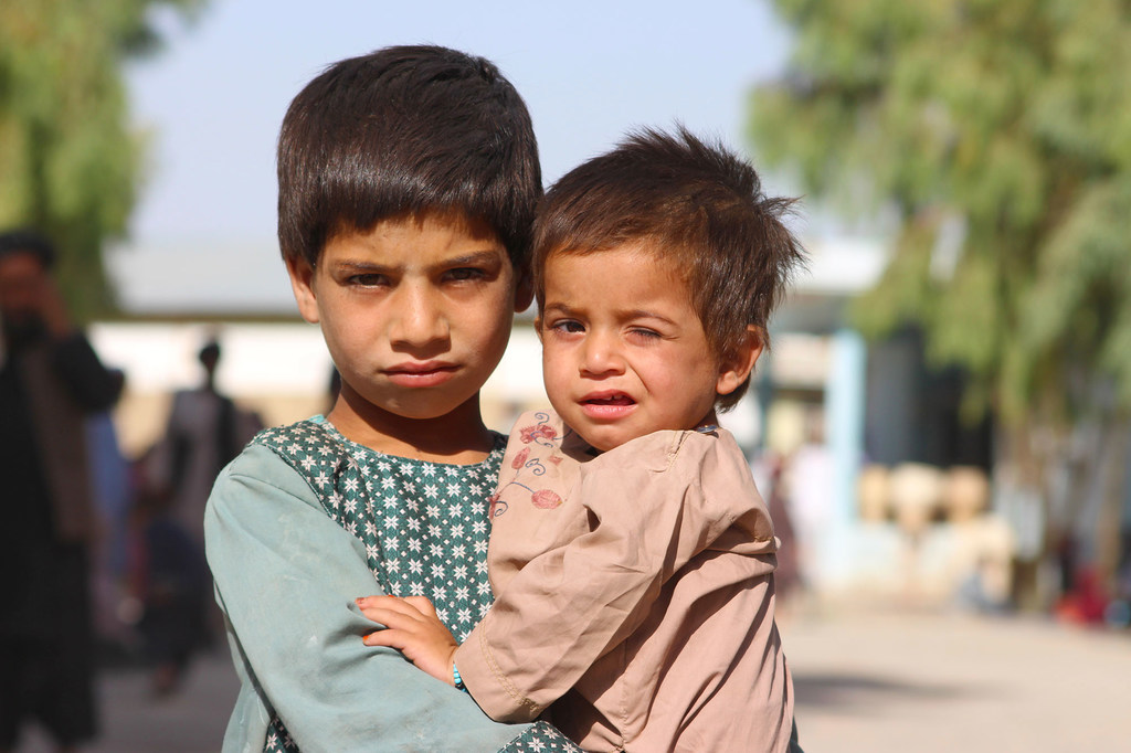 Un niño de cinco años sostiene a su hermano menor en un campo de desplazados en Kandahar, al sur de Afganistán.