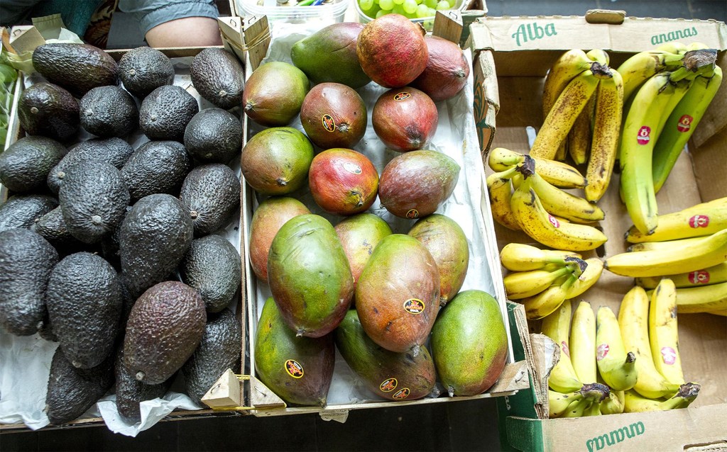 Aguacates, mangos y bananas en un mercado.