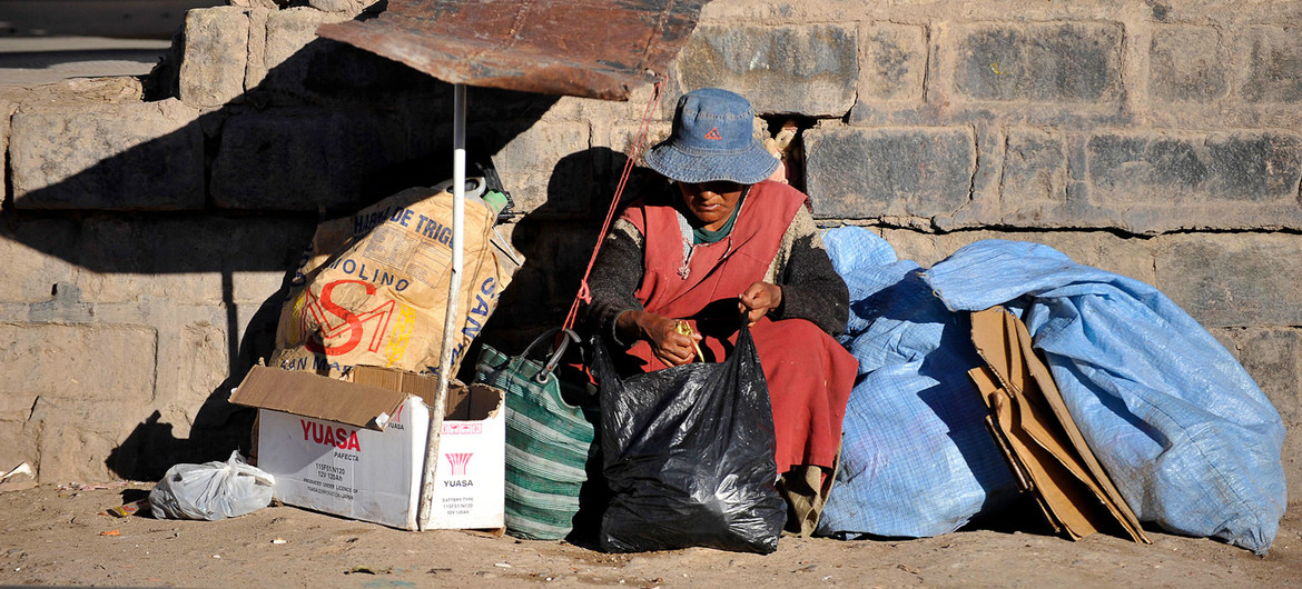 Una mujer sin hogar sentada junto a una vía férrea en la ciudad de Potosí, en Bolivia.