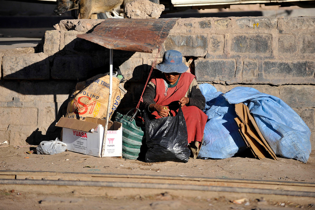 Una mujer sin hogar sentada junto a una vía férrea en la ciudad de Potosí, en Bolivia.