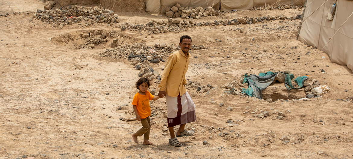 Un padre y su hijo caminan por un campo de desplazados internos cerca de la ciudad de Marib, en Yemen.