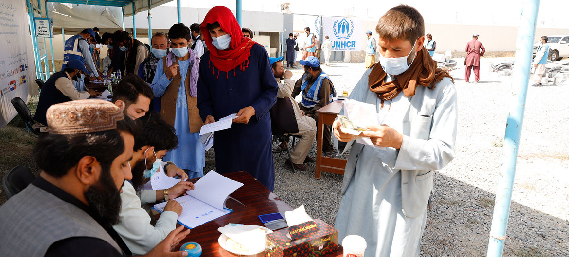Unas personas desplazadas reciben asistencia en un centro de distribución de Kabul, en Afganistán.
