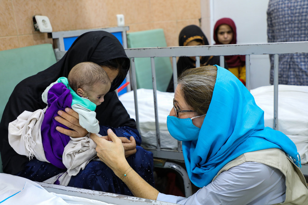La jefa de comunicación de UNICEF en Afganistán, Sam Mort, interactúa con un niño en una sala de tratamiento de la desnutrición del Hospital Infantil Indira Gandhi de Kabul, en Afganistán.