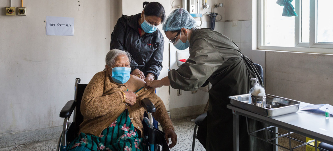 Una anciana recibe la vacuna COVID-19 en un hospital de Katmandú, Nepal.