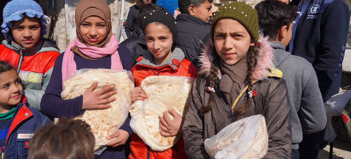 Niños reciben pan en Alepo, Siria, donde el PMA ayuda en la distribución de comida. 