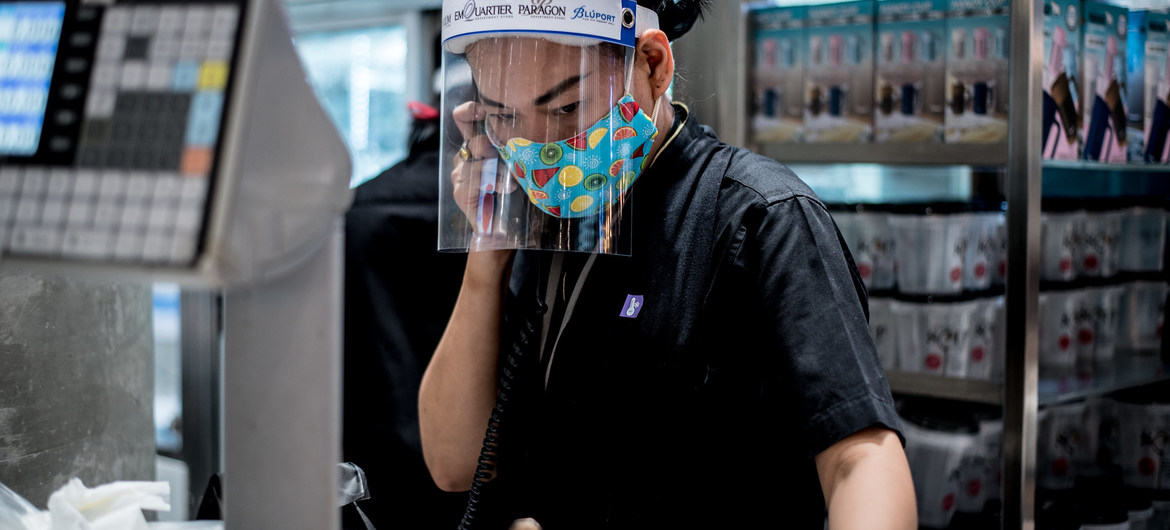 Una mujer trabaja en un centro comercial de Bangkok, Tailandia protegida con una pantalla contra la covid19