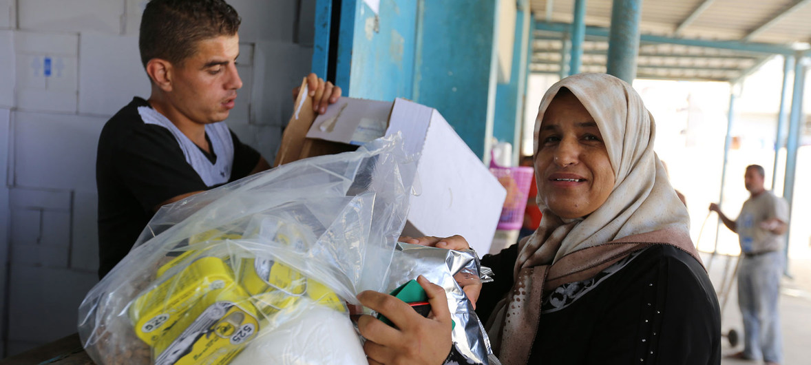 Una refugiada palestina recibe ayuda de la UNRWA en un centro de Gaza