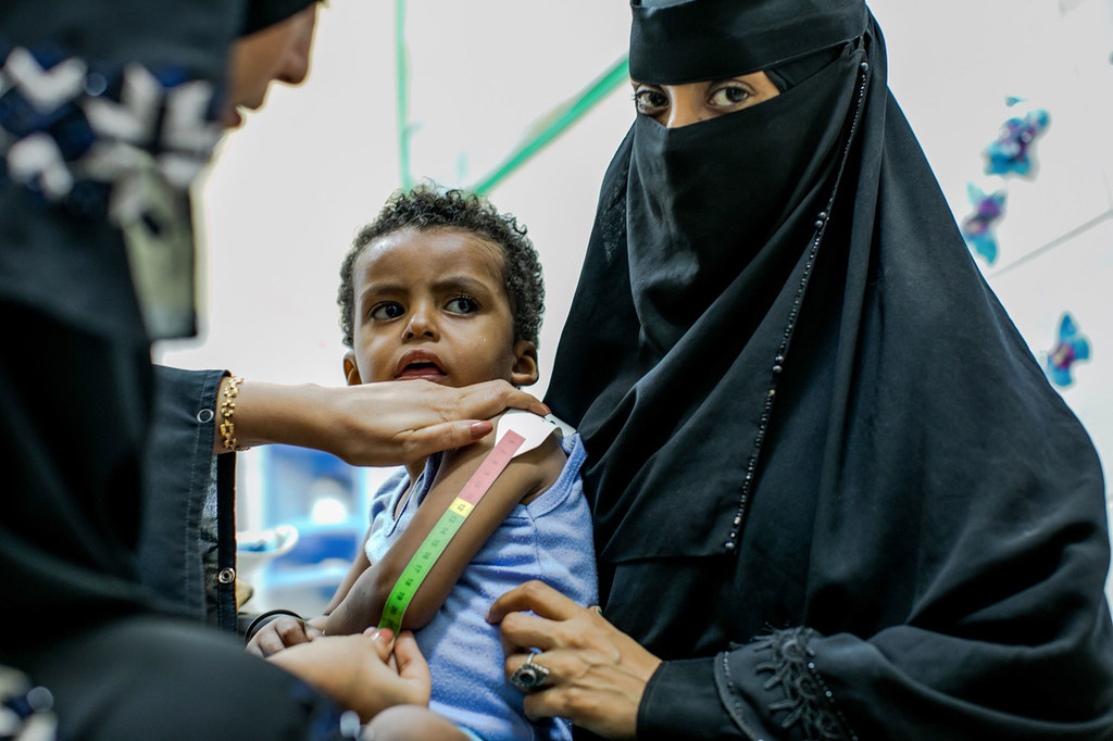 La trabajadora sanitaria Asia El-Sayeed Ali mide el brazo de un niño que sufre de desnutrición severa.