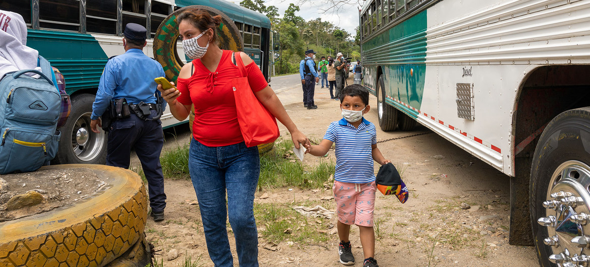 En la frontera de Honduras con Guatemala, la policía detiene los autobuses con migrantes para revisar sus documentos y resultados de la prueba del COVID-19.
