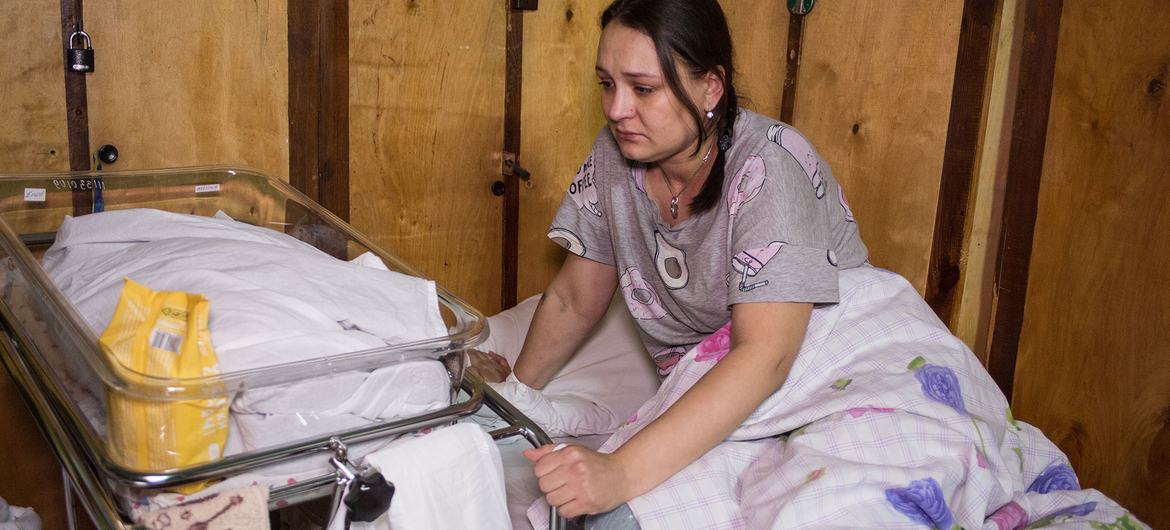 Una madre que acaba de tener a su bebé en una sala de maternidad improvisada en un hospital de Kyiv, Ucrania.