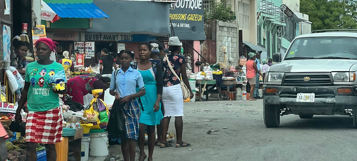 Una acera llena de gente con varios artículos a la venta en un barrio de Puerto Príncipe.