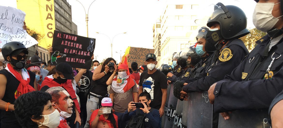 Un grupo de manifestantes se arrollidan ante la policía en las calles de Lima,la capital peruana.