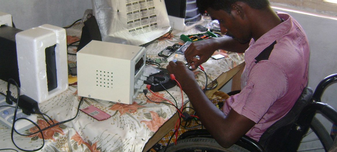 Un joven con discapacidad trabajando en una compañía de reparación de teléfonos móviles en Sri Lanka. 