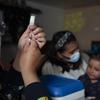 Una niña de dos años recibe una vacuna en su casa en Ecuador 