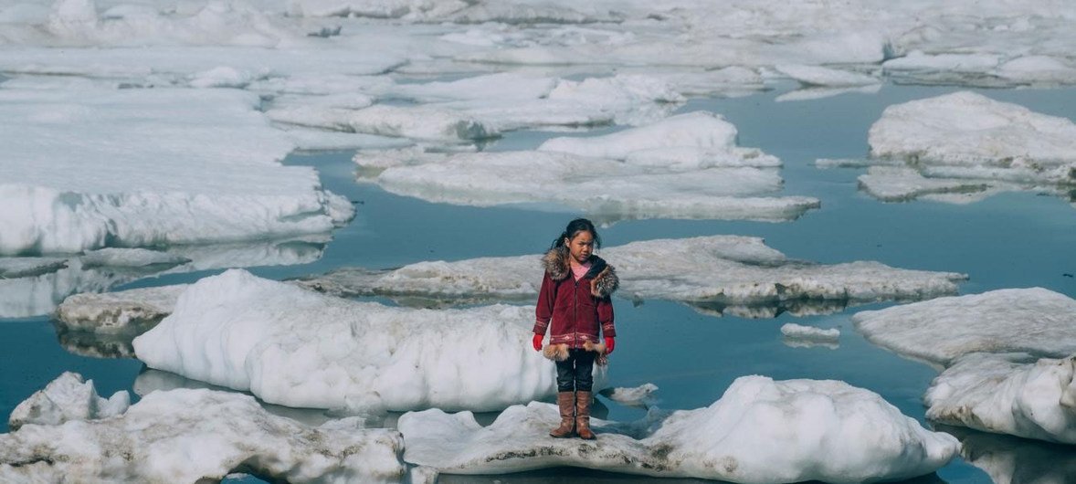 Una niña camina por las capas de hielo del Ártico en Barrow, Alaska. La pérdida de hielo en el Ártico es uno de los muchos efectos del calentamiento global.