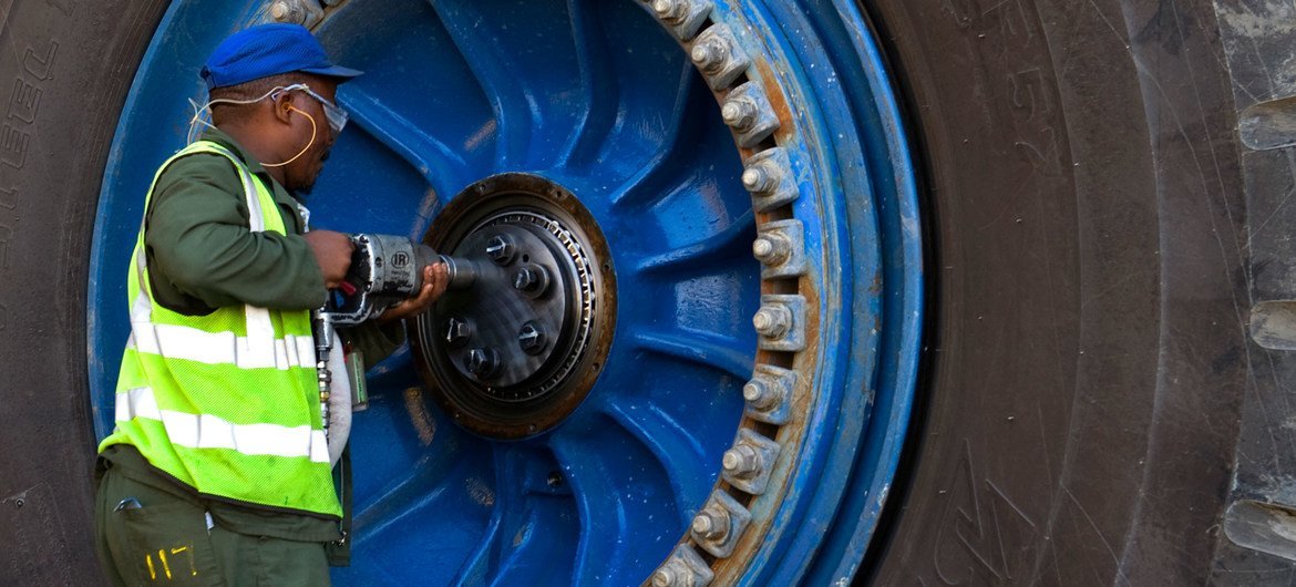 Un trabajador repara una rueda de un camión de transporte gigante en una mina de uranio de Namibia.