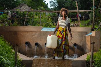 Una mujer recoge agua de una fuente desarrollada por UNICEF en la provincia de Kasai, R.D. Congo.