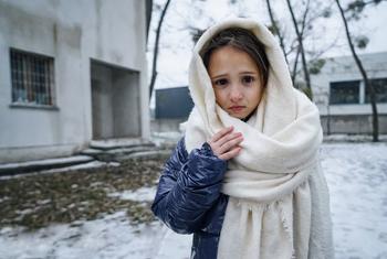 Una niña de 8 años delante de un edificio de Irpin, Ucrania, donde su madre y su hermana comparten una pequeña habitación.