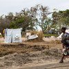 Una mujer pasea con su bebé en las afueras de Beira, Mozambique, en un reasentamiento para las personas desplazadas por los ciclones  Idai y Keith