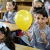 Estudiantes refugiados palestinos en una escuela de primaria muestran su contento por el regreso a las clases tras cinco meses de suspensión