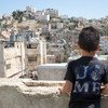 Hamid, de 8 años de edad, se asoma a la vieja ciudad de Hebrón desde el techo de su casa. (12 de julio de 2018).