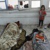 Una niña mira a sus hermanos dormir en el piso de un aula de una escuela de la UNRWA en Gaza