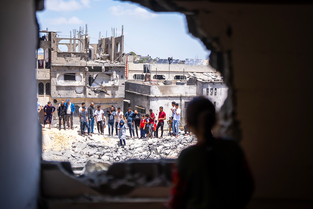 La gente observa los daños a las viviendas de un barrio en Gaza.